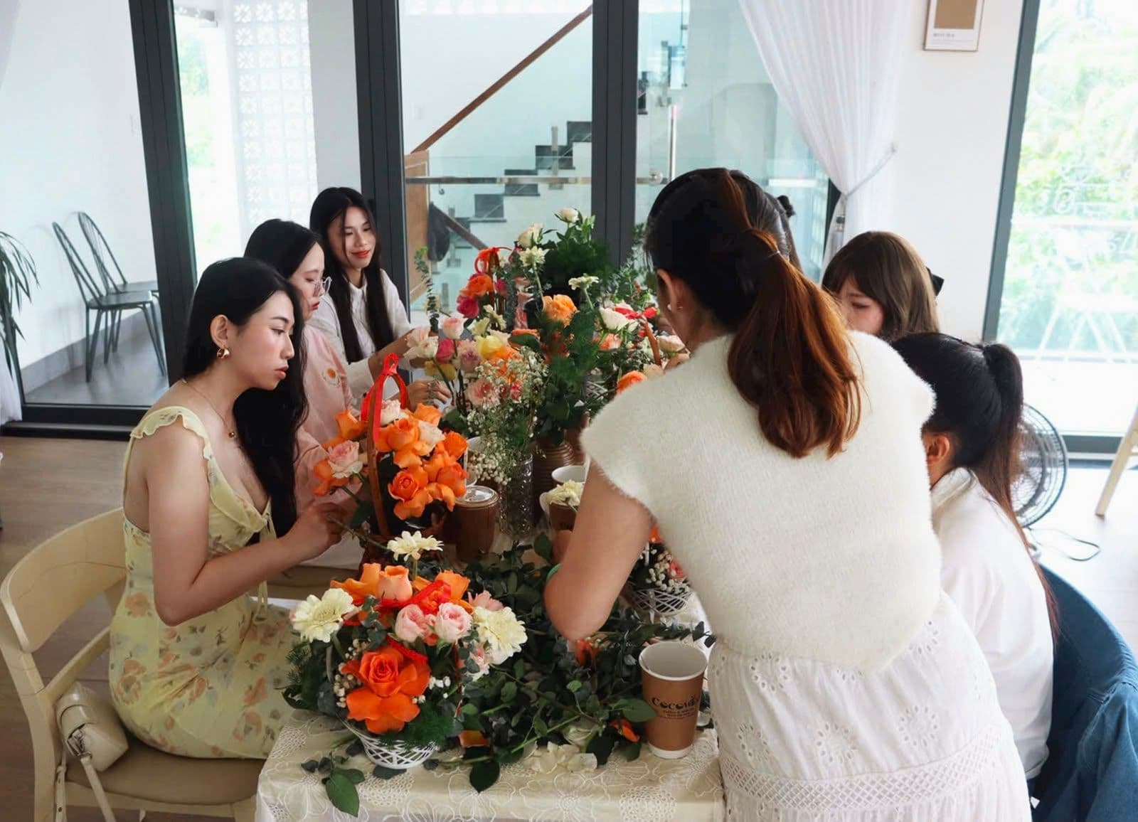 Các bạn nữ và cô giáo đang cùng nhau làm bó hoa.